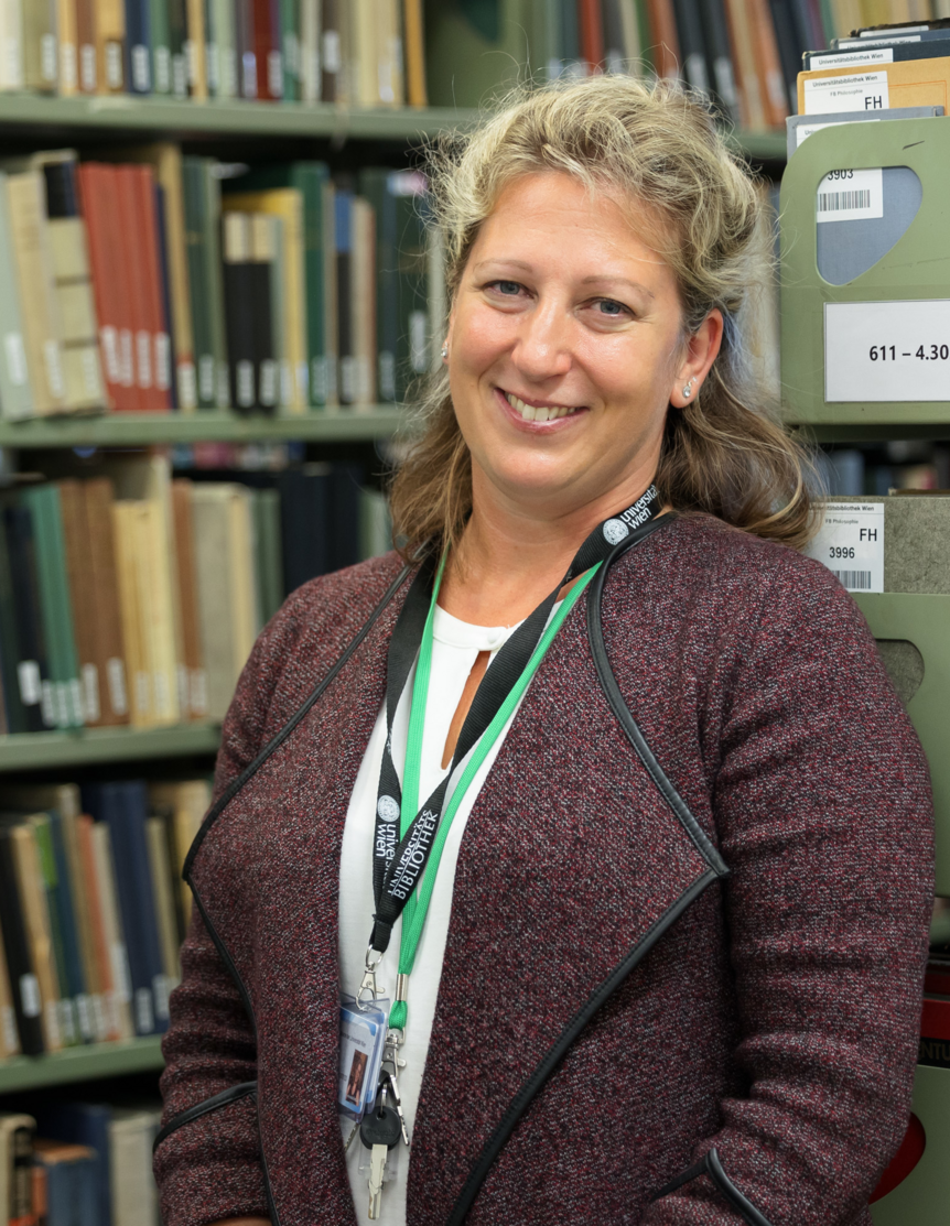 Bibliothekarin vor Bücherregalen