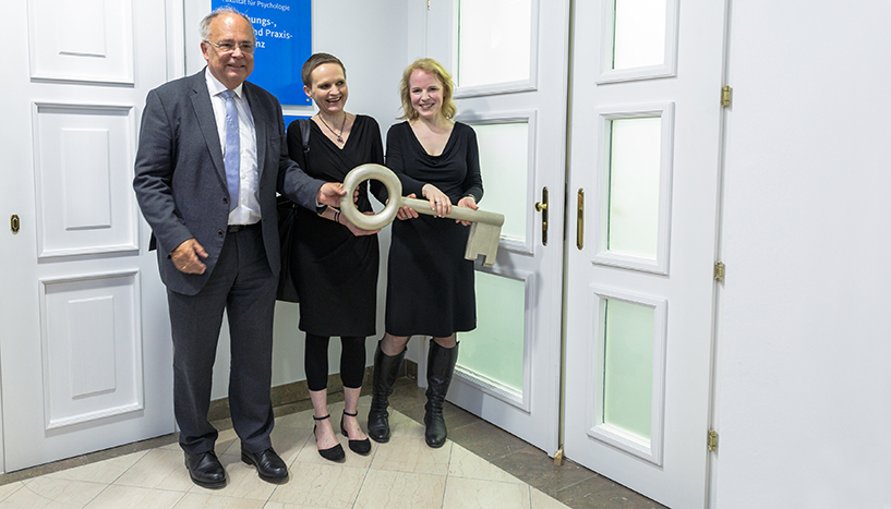 Rektor Heinz W. Engl, Dekanin Barbara Schober und Ambulanzleiterin Ricarda Nater-Mewes eröffnen die Forschungs-, Lehr- und Praxisambulanz am 23. Mai 2018 mit einem großen goldenen Schlüssel.