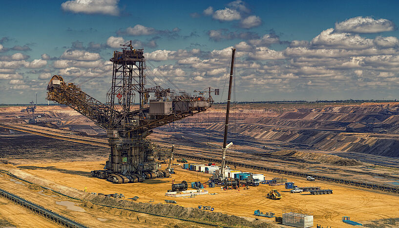 Extraction sight with heavy machinery, marks of human activity on a desolate landscape