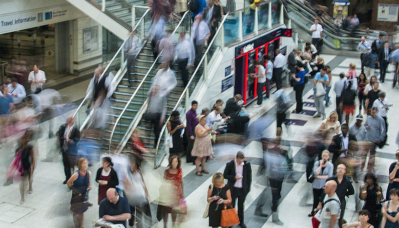 London U-Bahnstation, Menschen auf Rolltreppen und in einer Wartehalle